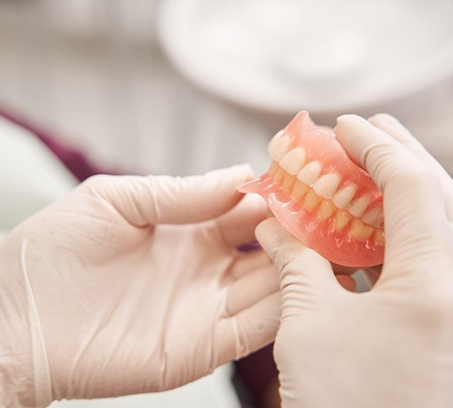 Dentist holding dentures