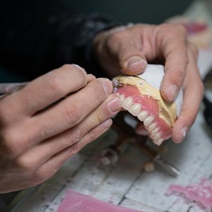 Man carving dentures