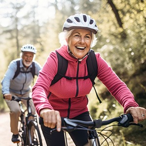 Senior couple smiling while riding their bikes on trail